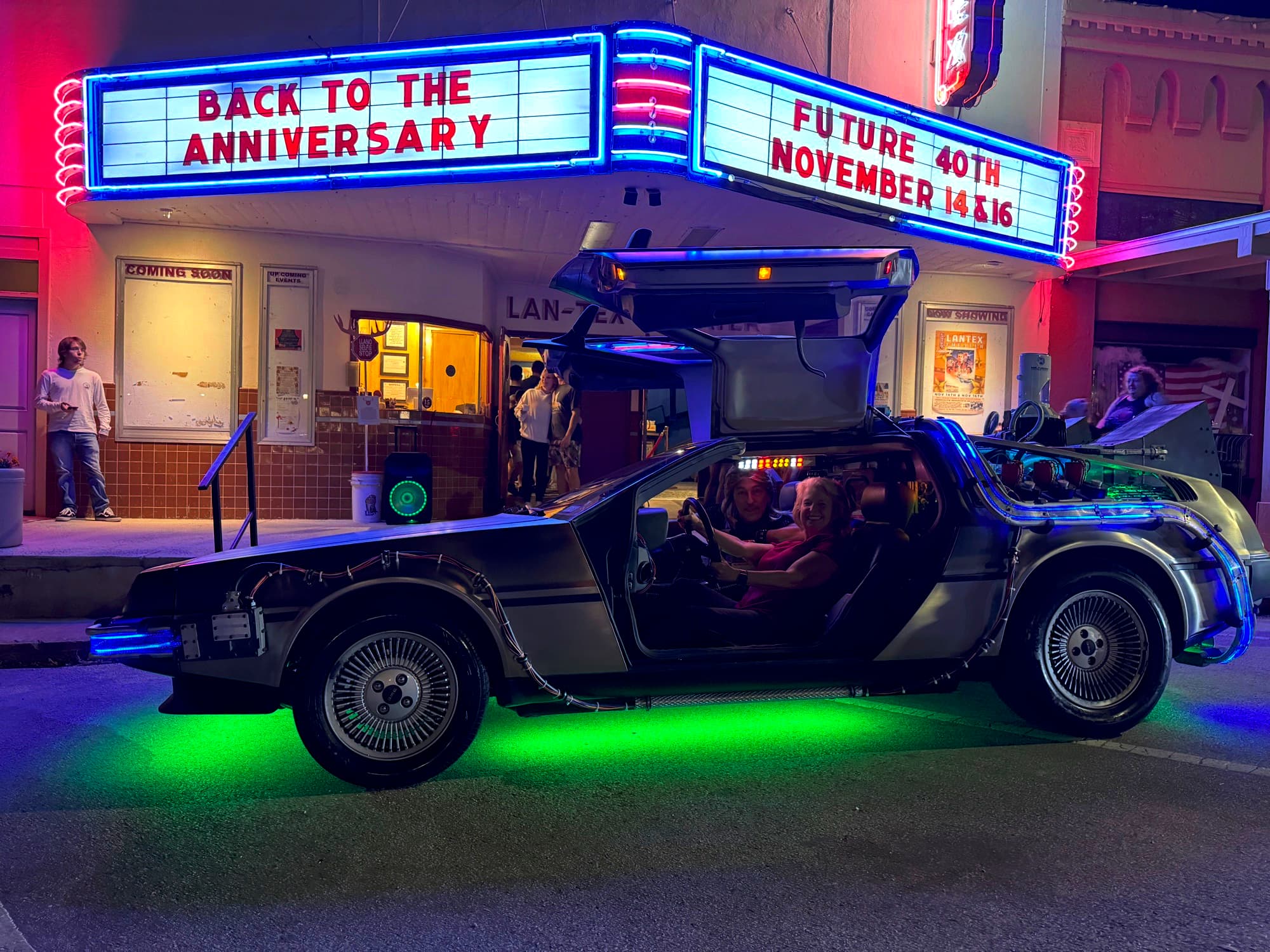A DeLorean time machine parked under the lit LanTex marquee for the Back to the Future 40th anniversary